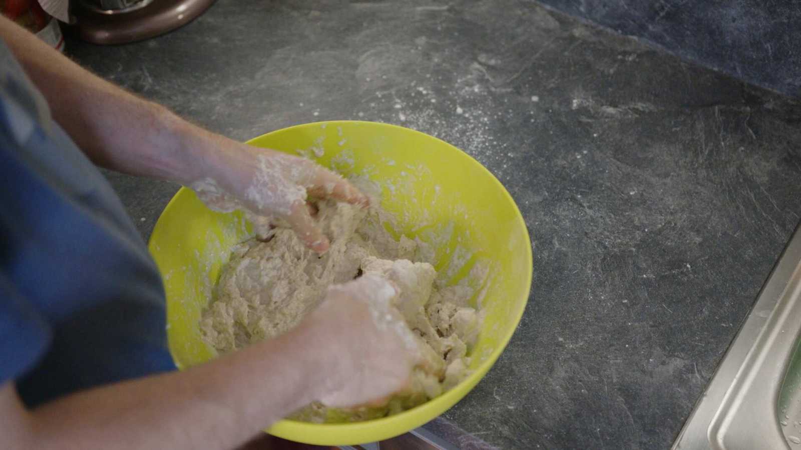 Wet dough being kneaded in bowl