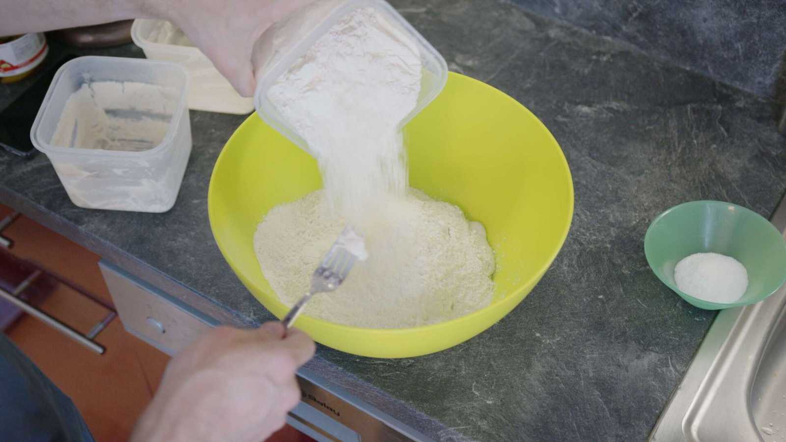 Flour getting added into a large bowl