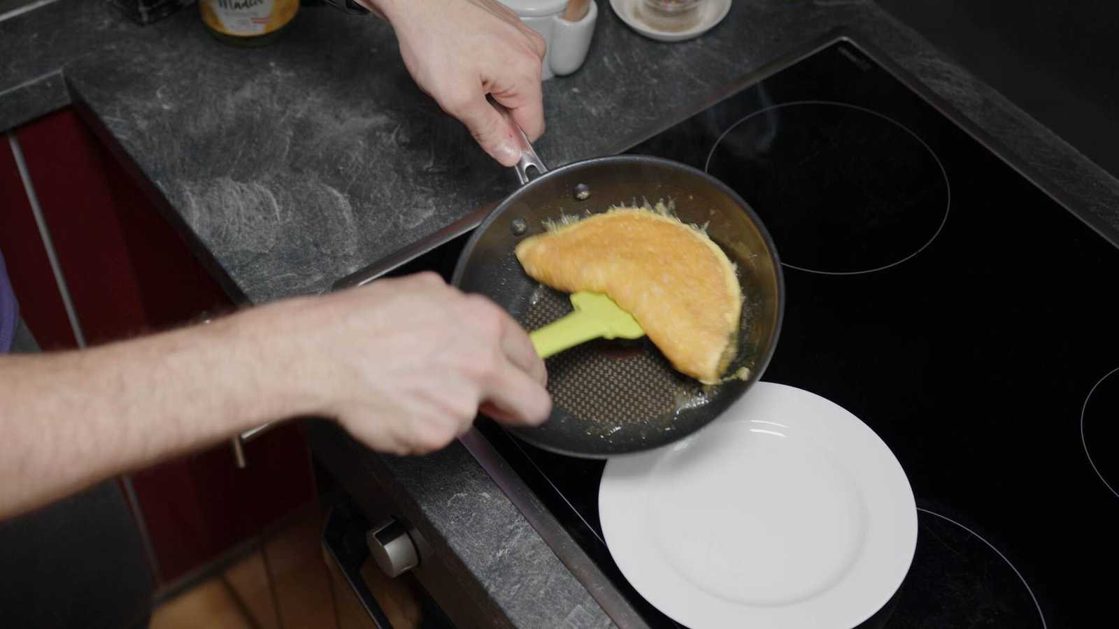 Flipped omelette being taken out of the pan with a spatula