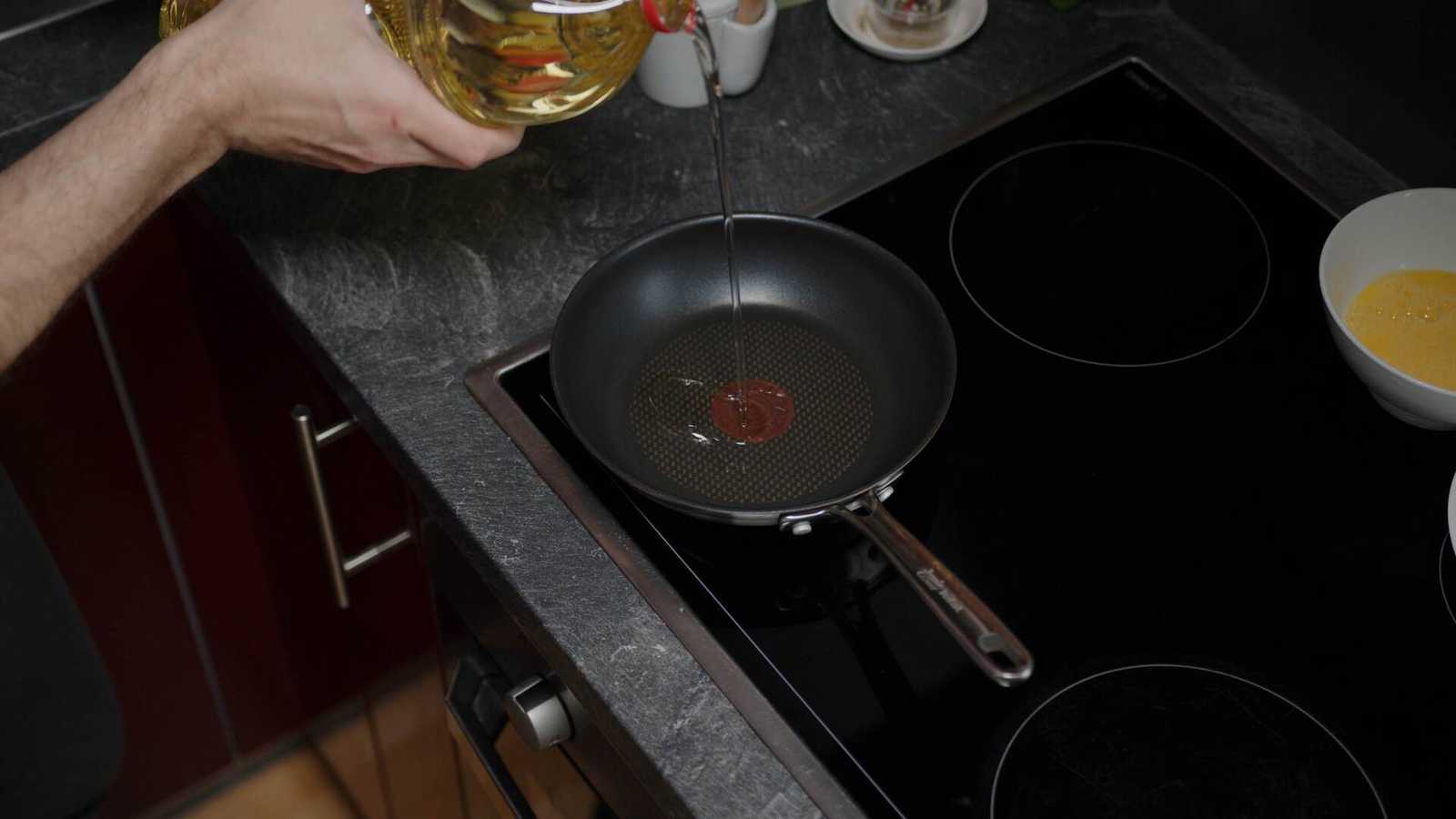 Oil dripping from a bottle into a pan