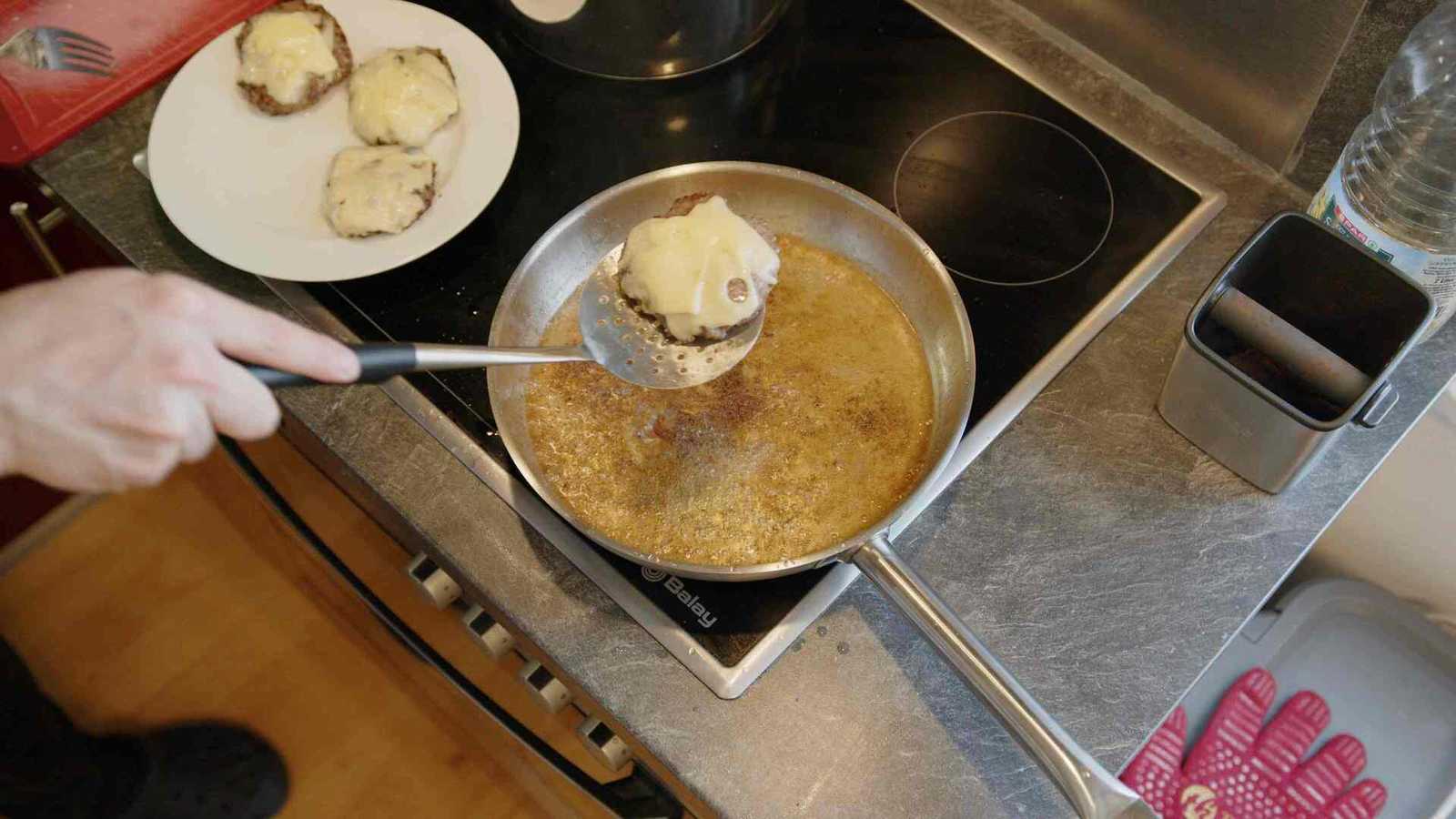 Patties with cheese being taken out of the pan