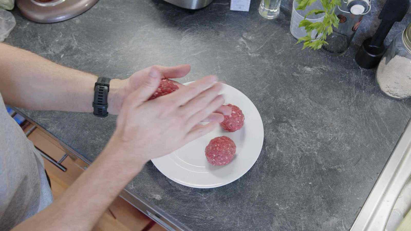 Flattening meat between hands to a thin patty