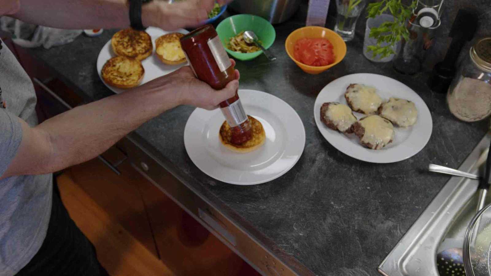 Ketchup from a bottle landing on the bun