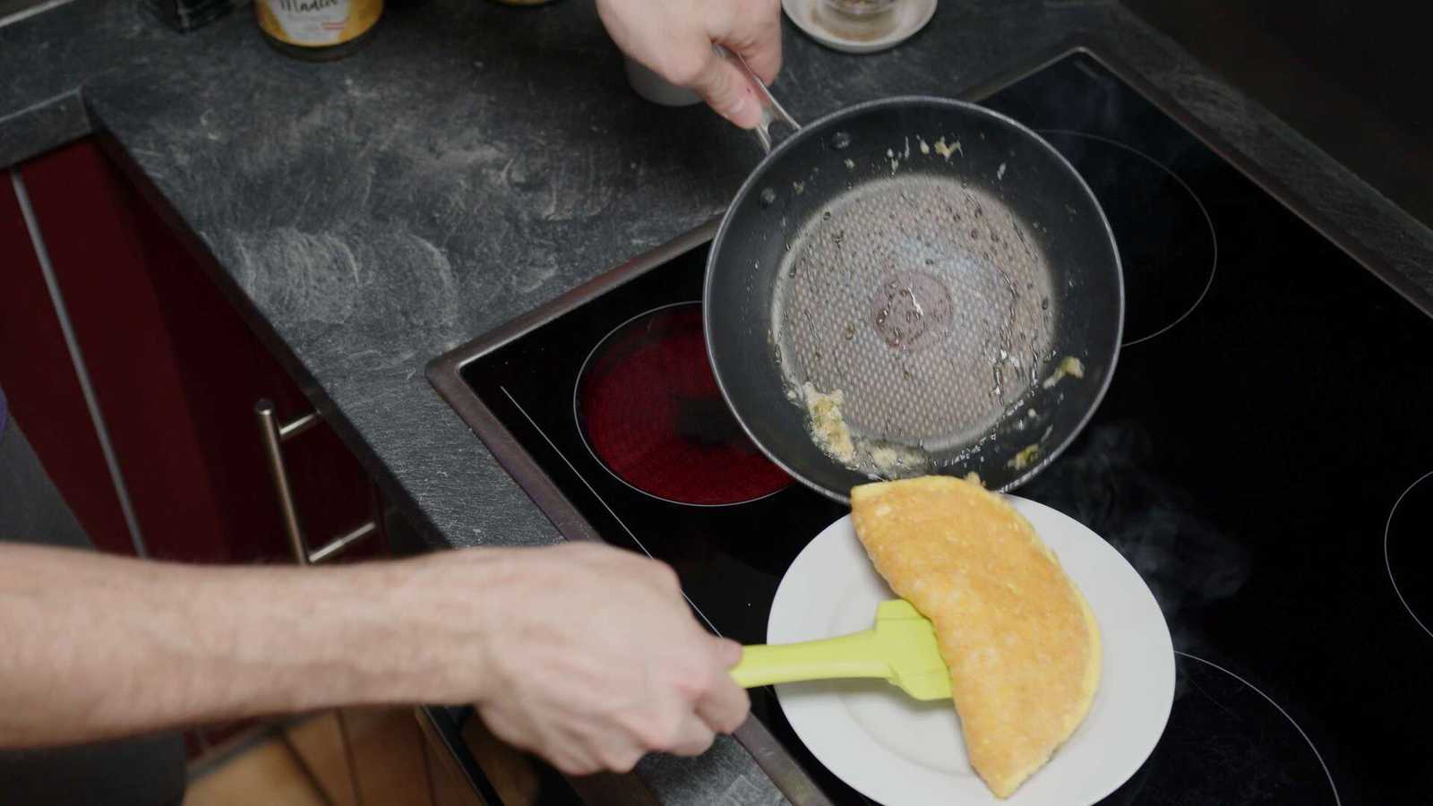 Omelette being put onto a plate for serving